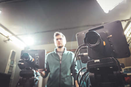 Male cameraman is operating a film camera in a television recording studioの写真素材