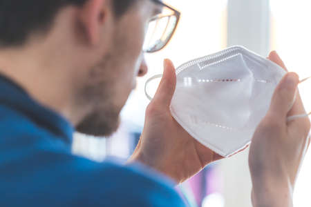 Young man in pulling on ffp2 anti corona maskの写真素材