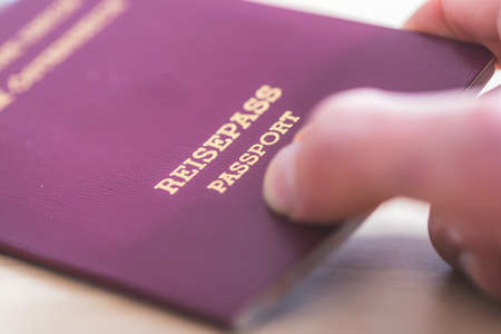 Close up of fingers holding a passport for traveling, airport, "Reisepass Passport"の写真素材