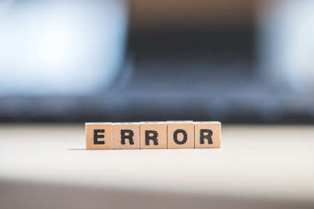 Wooden cubes with the letters "Error" are lying on a laptopの写真素材