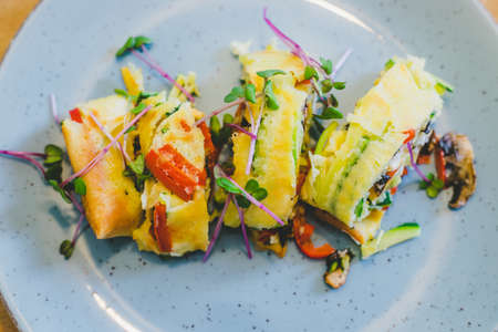 Close up of egg omelet with fresh vegetables. Placed on white ceramic plate.の写真素材