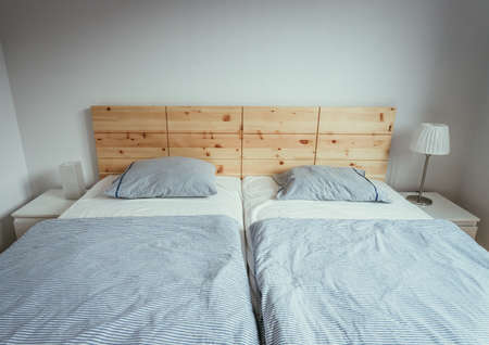 Large comfortable stone pine bed in bedroomの写真素材