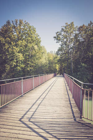 Wooden bridge over a river in spring timeの写真素材
