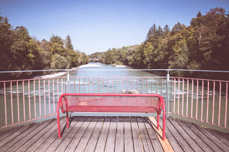 Red bench on a wooden bridge, riverの写真素材