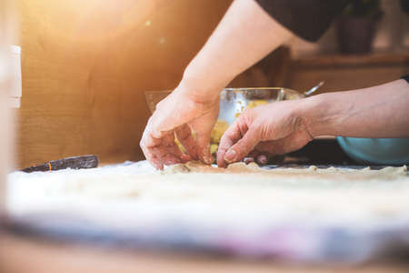 Close up of woman rolling traditional dough in the kitchenの写真素材