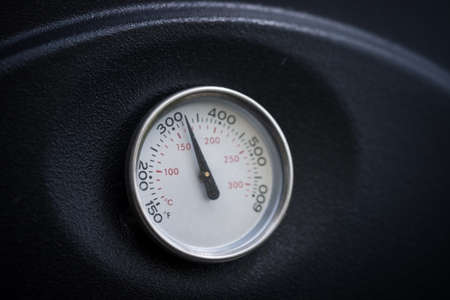 Close up of barbecue or smoke grill circular thermometer, black surfaceの写真素材