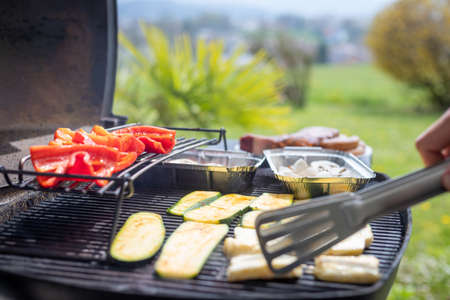 Close up of cheese and vegetables on gas grill. Summer time, outdoors.の写真素材