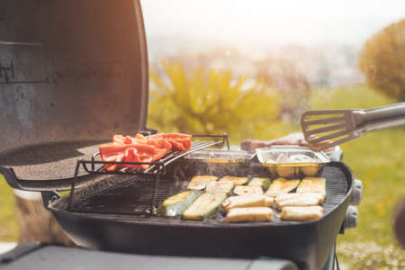 Close up of cheese and vegetables on gas grill. Summer time, outdoors.の写真素材