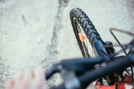 Close up picture of a mountain bike tire, blurry handlebar, summer dayの写真素材