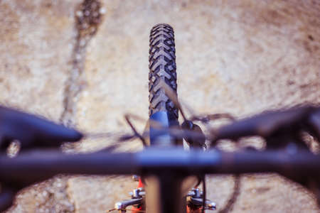 Close up picture of a mountain bike tire, blurry handlebar, summer dayの写真素材