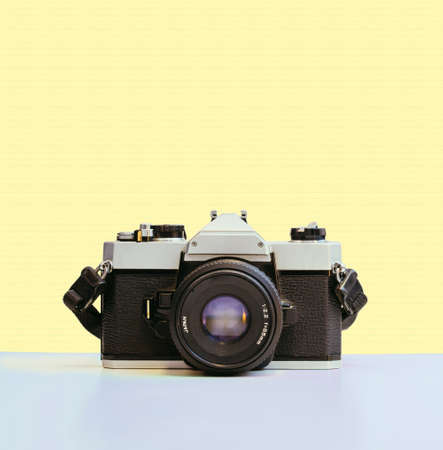 Retro vintage photography camera on yellow colored backgroundの写真素材