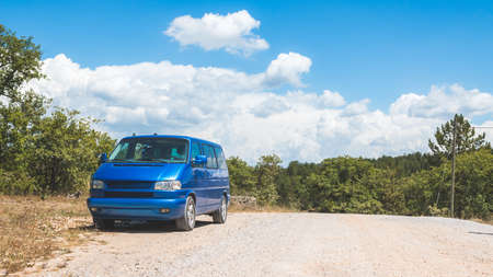 Retro minivan car standing on side of the desert road in the wildernessの写真素材
