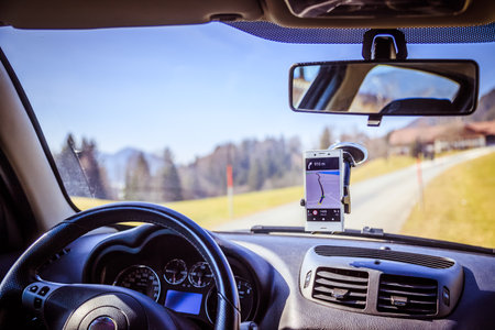 Interior of a modern car on a sunny day. Smartphone on mobile mount, used as a navigation device