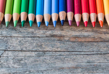 Set of multi-colored pencils on a rustically wooden table, copy spaceの写真素材