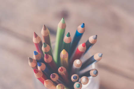 Colored pencils in a can on rustic wooden tableの写真素材
