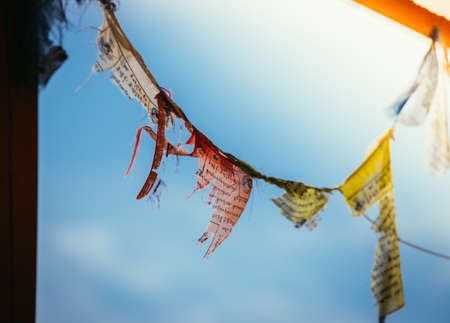 Colorful tibetan prayer flag in the wind, blue skyの写真素材