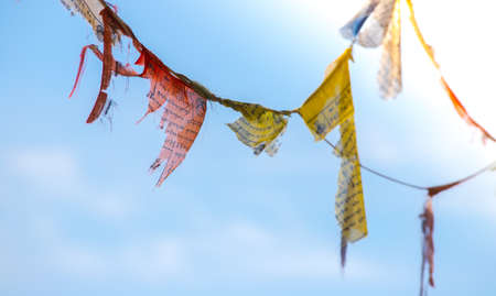 Colorful tibetan prayer flag in the wind, blue skyの写真素材