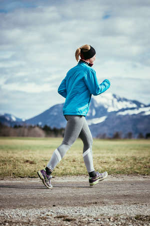 Young woman is jogging in the countrysideの写真素材