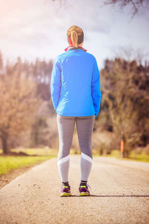 Girl in sportswear is waiting to start her training, countrysideの写真素材