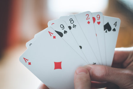 Young man is playing cards, cutout of his handsの写真素材