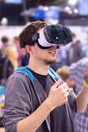 Young man is using virtual reality glasses on an expo