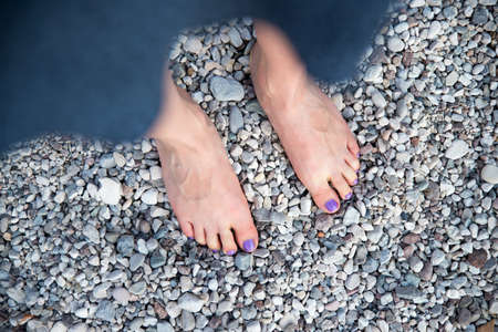 Girls feet on the pebble beachの写真素材