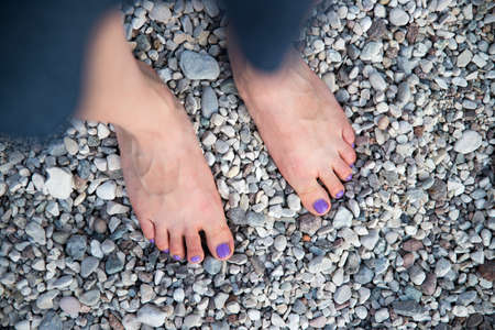 Girls feet on the pebble beachの写真素材