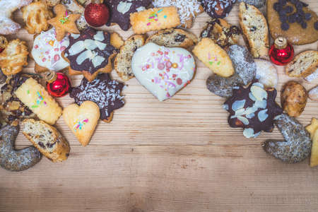 Homemade Christmas cookies, powdered sugar and Christmas bauble on a rustic wooden table. Copy space.の写真素材