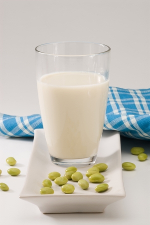 Soy milk in a glass  Fresh soy beans in foreground  White background の写真素材