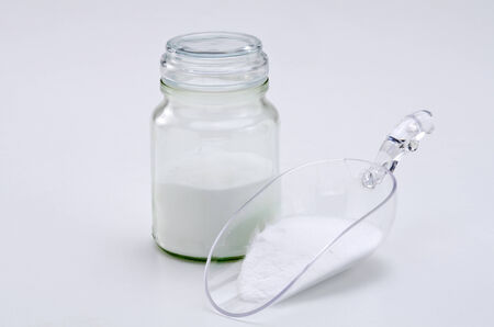 Sodium bicarbonate in a glass jar. White background.の写真素材