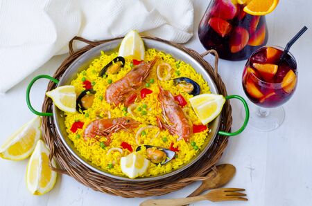 Spanish Cuisine. Paella in a pan view from above and fresh sangria in background. Taken in daylight.の写真素材