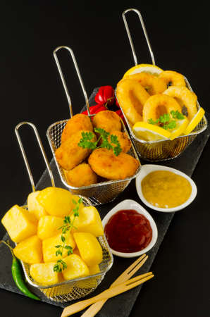 Spanish Tapas. Spicy fried potatoes in hot sauce, Ham Croquettes and Fried Squid Rings. Patatas bravas, Croquetas de Jamon, Calamares a la Romana.の写真素材