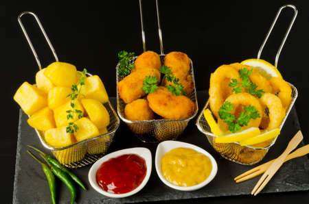 Spanish Tapas. Spicy fried potatoes in hot sauce, Ham Croquettes and Fried Squid Rings. Patatas bravas, Croquetas de Jamon, Calamares a la Romana.の写真素材