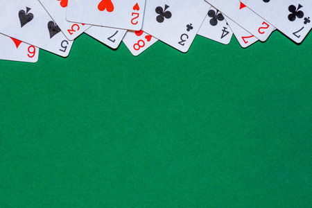 Cards on green felt casino table. Background with copy space in center