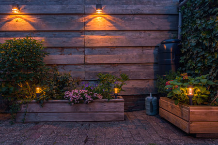 Solar powered outdoor lighting illuminating a garden with flowers and plants.の写真素材