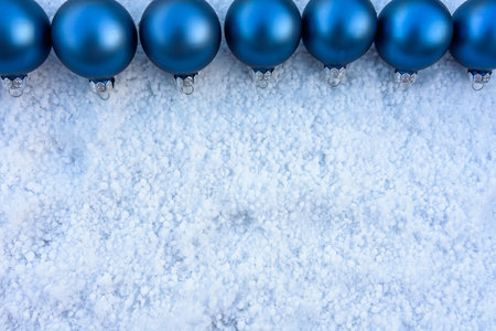 blue christmas balls in a row on snow. Christmas card conceptの写真素材