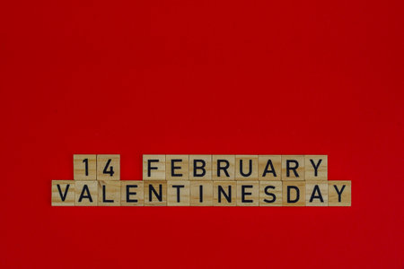 February 14 Valentine's day in wooden blocks on a red background.の写真素材