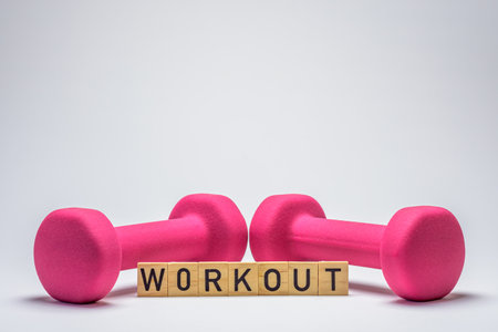 dumbbell isolated on white wooden blocks spelling workoutの写真素材