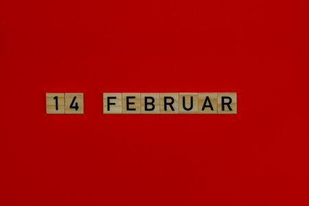 February 14 in wooden blocks on a red background. Valentine's day conceptの写真素材