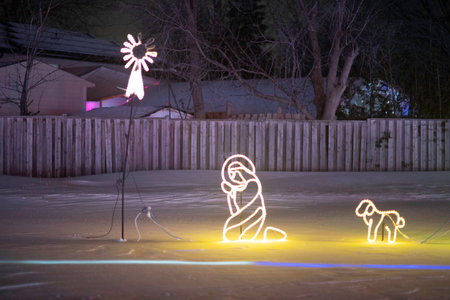 Children play ice hockey at night in the yard of the house.の写真素材