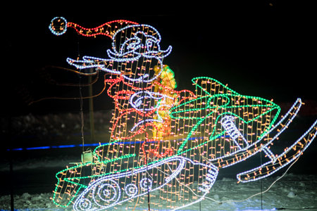 A lighted Santa Claus on a sleigh with colorful lights.の写真素材