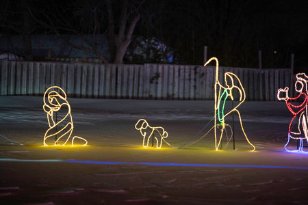 Children's figure skating on an ice rink at night in winter.の写真素材