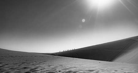 Hikers climb a dune in Namibia.