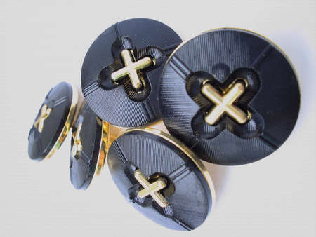 golden and black buttons on white backgroundの写真素材