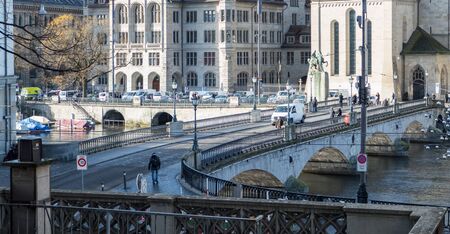 People walking on the munster bridge of river Limmat in the city center of Zurich, Switzerland