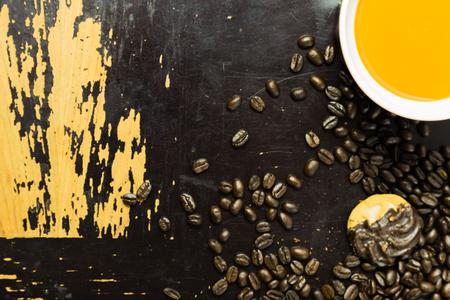 A  coffee mug, a cookie  and coffee beans on a scratchy. old wooden surfaceの写真素材