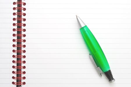 Notepad and a green penの写真素材