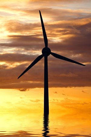 A wind turbine in the sea under sunset