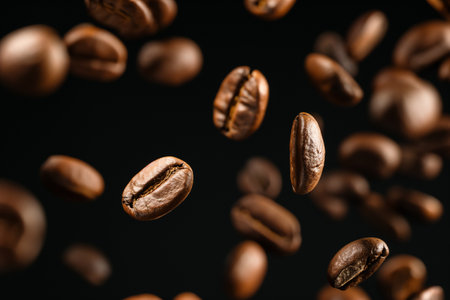 Flying coffee beans on black background, levitation effect, close upの素材