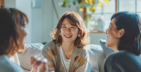 Happy asian women sitting on sofa in living room at home.の素材